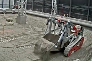 A close up of the Utah robot scooping regolith