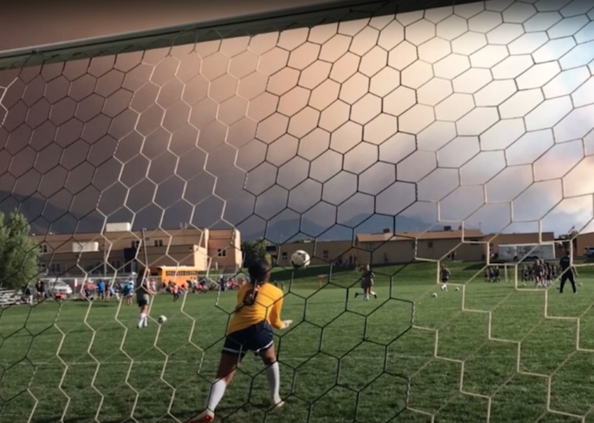 A smoke cloud passes over a youth soccer game.